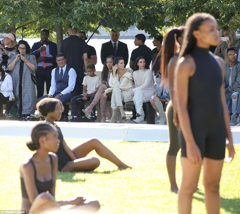 Fazendo uma pausa: as modelos começaram a se sentar na grama enquanto se cansavam de ficar de pé - enquanto Kim, Kylie e Kendall se sentavam na primeira fila parecendo um pouco entediadas