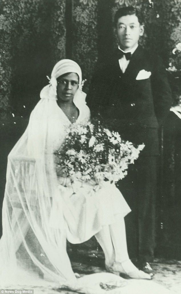 Um casal interracial não identificado é visto posando alegremente no dia do casamento