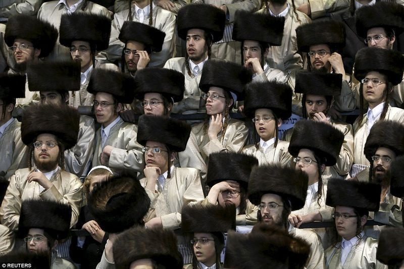 Juudi mehed osalevad pulmas traditsiooniliste shtreimel-mütsidega, kui nad toimuvat jälgivad